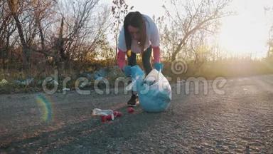 志愿者妇女捡起垃圾和塑料，用垃圾袋清洁公园。 人和生态。 环境